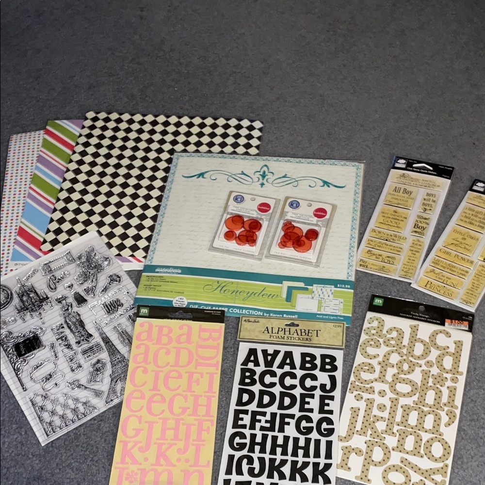 Assorted scrapbooking supplies. Clear stamps. Paper. Stickers.